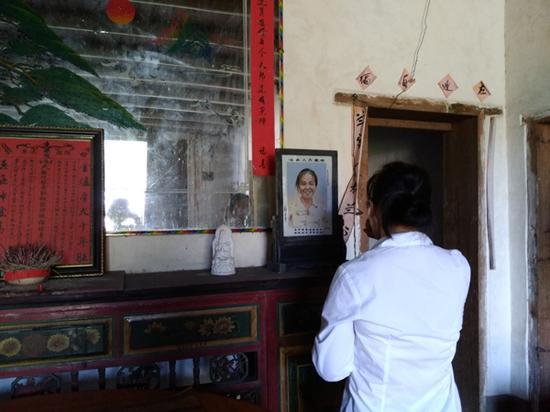 李春兰望着母亲的遗像喃喃自语,最终掩面哭泣。